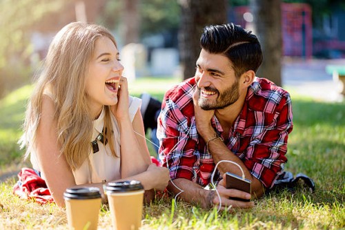 happy young couple listening music in the park - junk food stock pictures, royalty-free photos & images