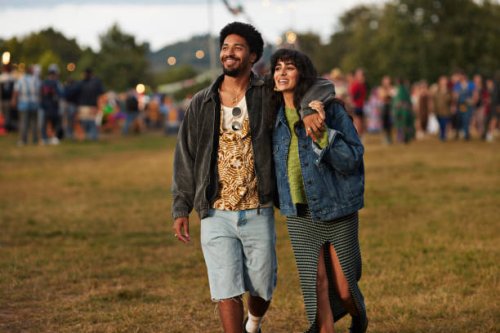 happy young couple looking away while walking at park - concert stock pictures, royalty-free photos & images