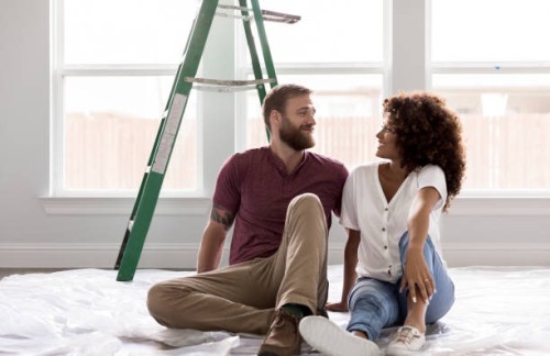 happy young couple take break from diy project - home decoration stock pictures, royalty-free photos & images