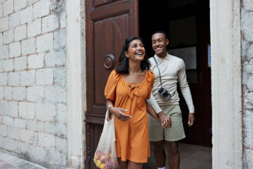 happy young couple walking out of doorway - travel stock pictures, royalty-free photos & images