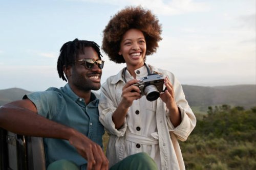 happy young couple with camera in national wildlife park - travel stock pictures, royalty-free photos & images