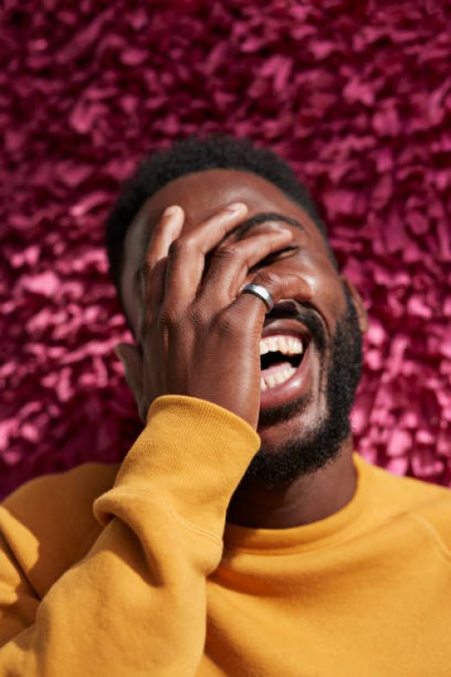 happy young man covering face against textured wall - fashion stock pictures, royalty-free photos & images