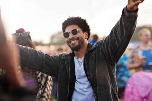 happy young man dancing with arms raised - concert stock pictures, royalty-free photos & images