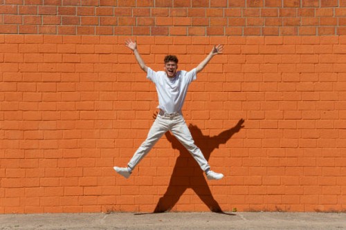 happy young man jumping mid-air - fashion stock pictures, royalty-free photos & images