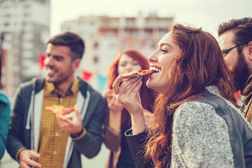 happy young people eating pizza outdoors - junk food stock pictures, royalty-free photos & images