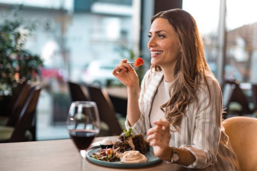 happy young woman eating lunch at a restaurant. - food stock pictures, royalty-free photos & images