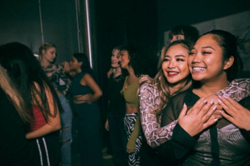 happy young woman embracing friend enjoying at nightclub - concert stock pictures, royalty-free photos & images