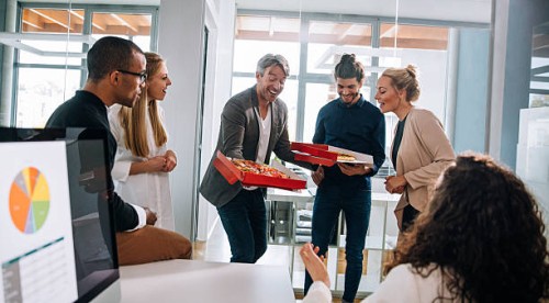 head of department surprises business colleagues with pizza. - junk food stock pictures, royalty-free photos & images