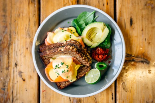 healthy breakfast with rye bread, salmon, poached egg, avocado and lime - food stockfoto's en -beelden