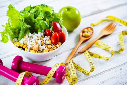healthy eating and exercising backgrounds: fresh healthy salad, dumbbells and tape measure with copy space - junk food stock pictures, royalty-free photos & images