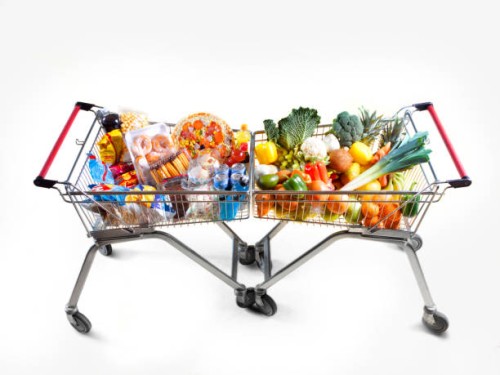 healthy food versus unhealthy food in opposing supermarket trollys - junk food stock pictures, royalty-free photos & images