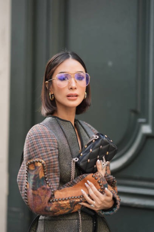 Heart Evangelista wears glasses, earrings, a leather bag outside Louis Vuitton, during the Womenswear Fall/Winter 2024/2025 as part of Paris Fashion...