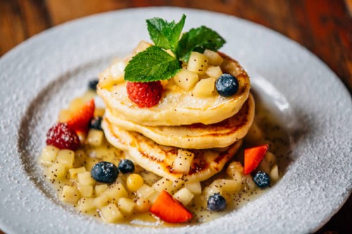 hearty stack of pancakes with maple syrup, fresh strawberry and blueberry on the plate - junk food stock pictures, royalty-free photos & images