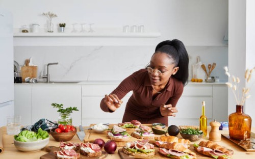 hermosa joven preparando sándwiches para la reunión social - food fotografías e imágenes de stock