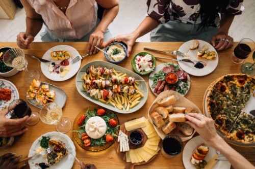 high angle shot of anonymous group of friends having lunch together at the dining table - food stock pictures, royalty-free photos & images