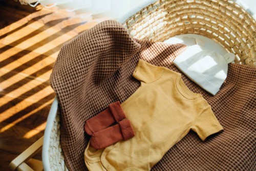 high angle shot of baby clothings and accessories in moses basket. precious moment in life. preparation for a new family member. expecting a new life concept. baby and new life concept - fashion stock pictures, royalty-free p