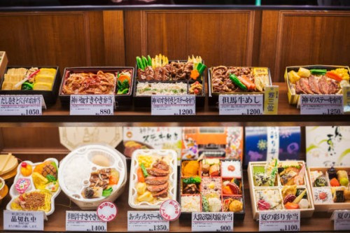 high angle view of a selection of bento boxes with traditional japanese foods on shelves. - junk food stock pictures, royalty-free photos & images
