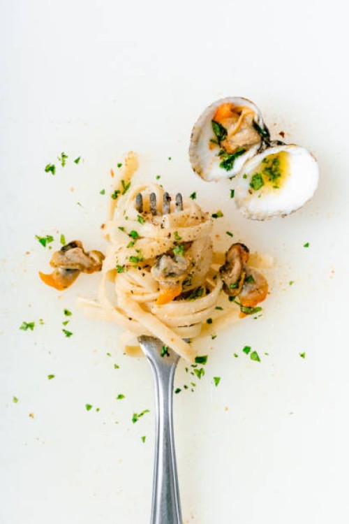 high angle view of clams and noodles in fork on white background - food stock pictures, royalty-free photos & images