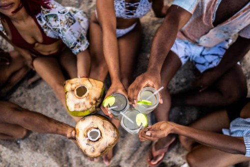 high angle view of friends making a celebratory toast on the beach - food stock pictures, royalty-free photos & images