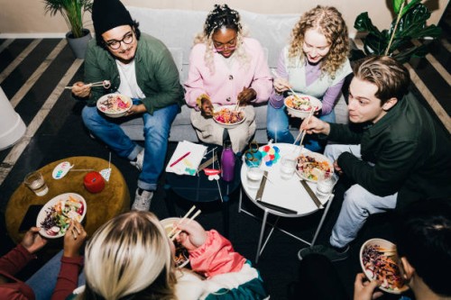 high angle view of multiracial male and female students enjoying food in college dorm - food stock pictures, royalty-free photos & images