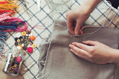high angle view of woman stitching fabric on table at home - fashion stock pictures, royalty-free photos & images