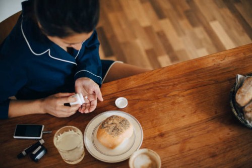 high angle view of woman taking medicine while having breakfast at table - food stock pictures, royalty-free photos & images