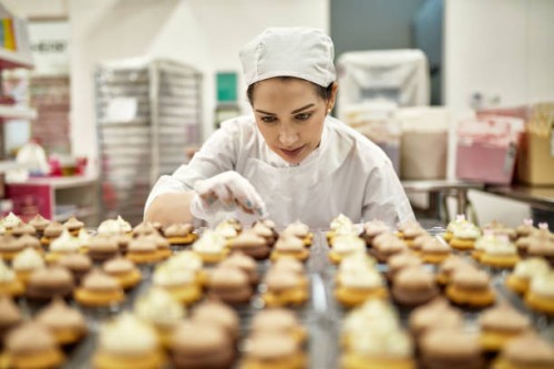 hispanic american female baker decorating vegan cupcakes - food stock pictures, royalty-free photos & images
