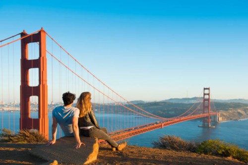 hispanic couple admiring golden gate bridge, san francisco, california, united states - travel stock-fotos und bilder