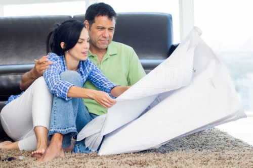 hispanic couple examining blueprints in living room - home decoration stock pictures, royalty-free photos & images