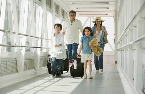 hispanic family walking through airport - travel stockfoto's en -beelden