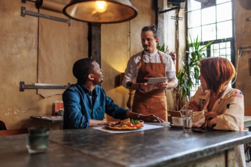 hispanic waiter taking order from multiracial couple. - food stock pictures, royalty-free photos & images