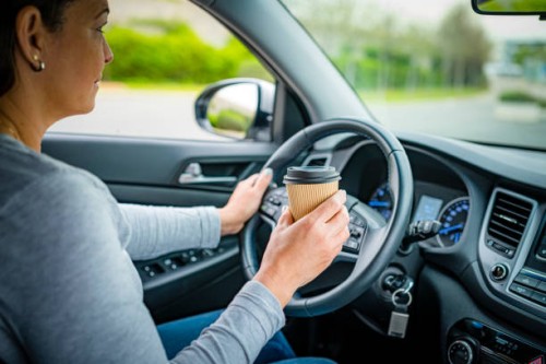 holding disposable coffee cup while driving - junk food stock pictures, royalty-free photos & images