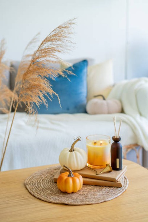 home autumn decor in warm shades. pumpkin, candle, dried flowers, pillows. - home decoration stock pictures, royalty-free photos & images