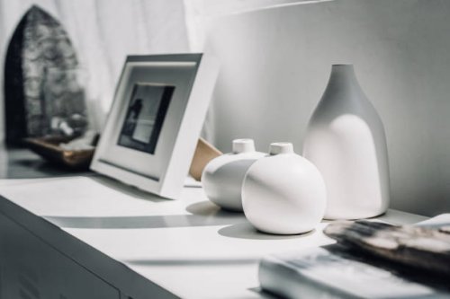 home decoration of neutral coloured vases and picture frame on a cabinet by the window in sunlight - home decoration stock pictures, royalty-free photos & images