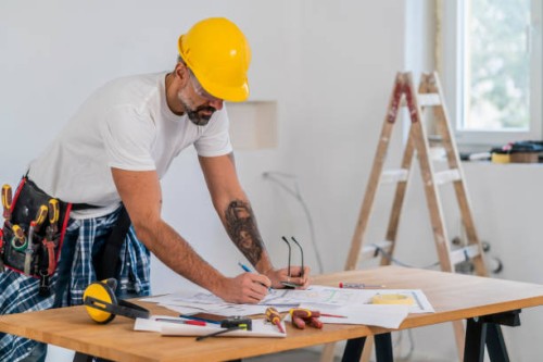 home diy, mature man working as carpenter underlining part of blueprint using pencil - home decoration stock pictures, royalty-free photos & images