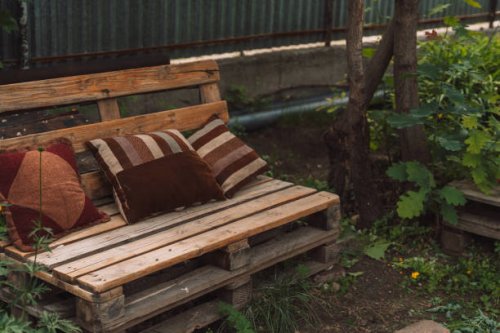 homemade bench from pallets with cushions in the yard - garden decoration stock pictures, royalty-free photos & images