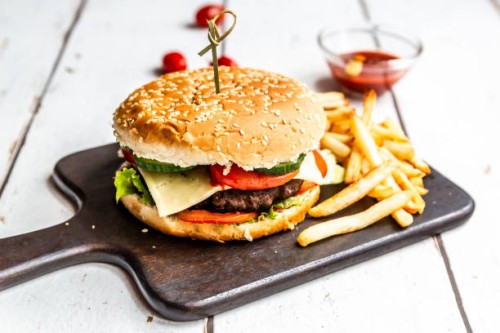 homemade hamburger with cheese, french fries, ketchup and tomato - junk food stockfoto's en -beelden