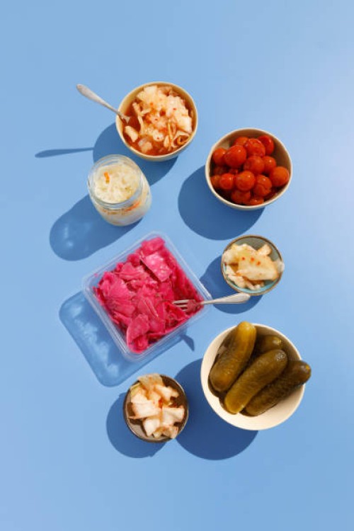 homemade kimchee, pickled cucumbers, tomatoes, cabbage with beets and sauerkraut on the blue background - food stock pictures, royalty-free photos & images
