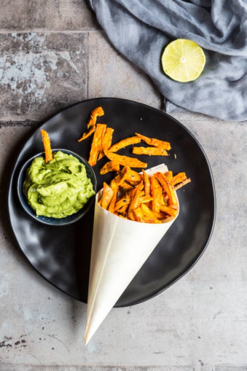 homemade sweet potato fries and bowl of guacamole - junk food stock pictures, royalty-free photos & images