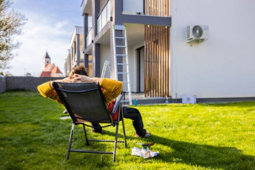 homme fatigué se reposant sur une chaise longue dans la cour tout en coloriant l’appartement - garden decoration photos et images de collection