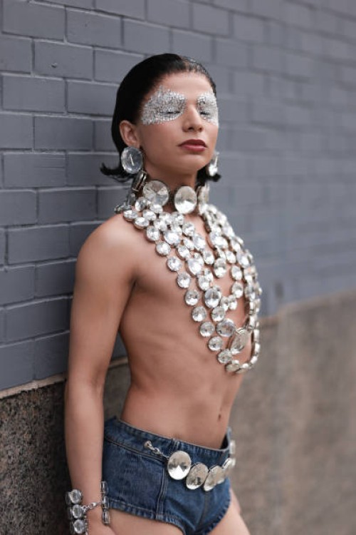 Honey Gonzales is seen wearing bejeweled Swarovski eye makeup, large round Swarovski crystals earrings, several layered necklaces with round...