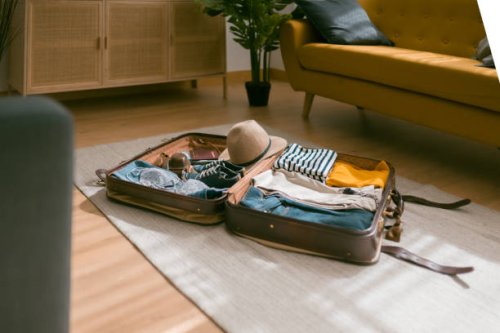 horizontal view of an open suitcase full of clothes ready to travel. - travel stock pictures, royalty-free photos & images
