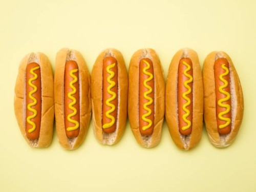 hot dogs against a plain background - junk food stockfoto's en -beelden