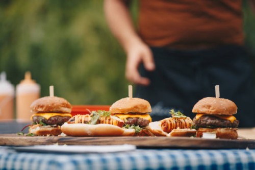 hot dogs and hamburgers placed on chopping board. - junk food stock pictures, royalty-free photos & images