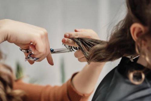 human hands hair cut using a scissors lock of hair - hairstyle stock-fotos und bilder