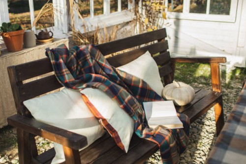 hygge home terrace with wooden bench with pillows on it, wooll blanket and book. - garden decoration stock pictures, royalty-free photos & images