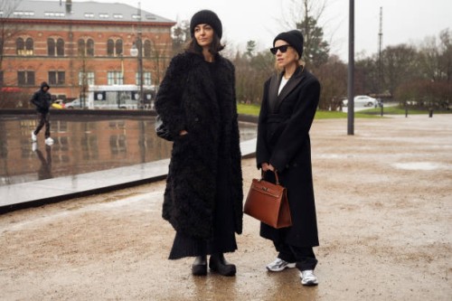 Ilenia Thoma wearing black long coat and hat and Tina Lundin wearing black long coat and brown bag outside MKDT in Copenhagen fashion week...