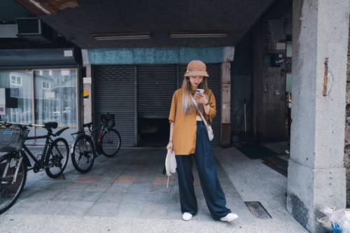 in asia, a young taiwanese waits for friends on the street. - fashion stock pictures, royalty-free photos & images