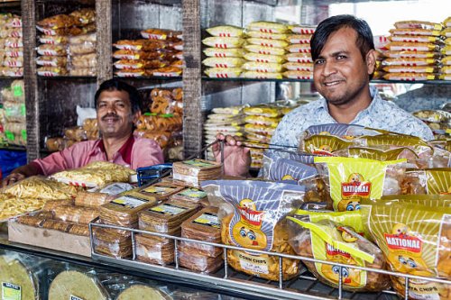 India Mumbai Apollo Bandar Colaba Causeway Market Shahid Bhagat Singh Marg snacks junk food sale display man coworkers.