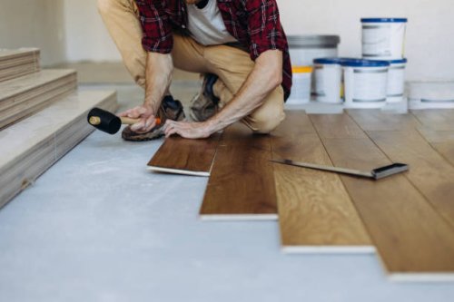 installing the parquet floor, a man hands fixing one tile with a hammer - home decoration stock pictures, royalty-free photos & images